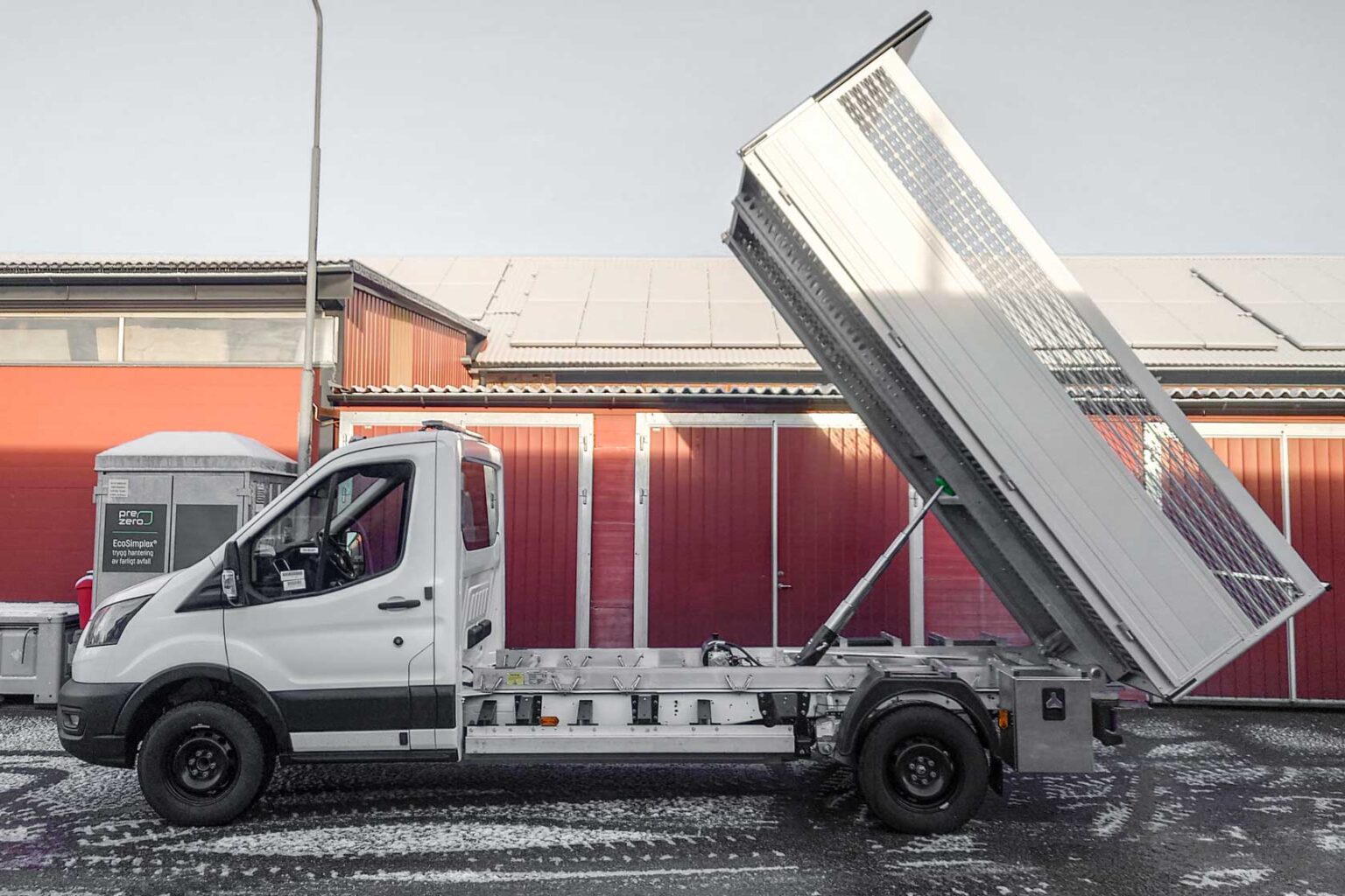 Tippflak Almeco Ford E-Transit elektrisk transportbil chassibil lätt lastbil. Extrautrustning: Lämförhöjning tippflak för flis- och rishantering, flaklåda under flak.