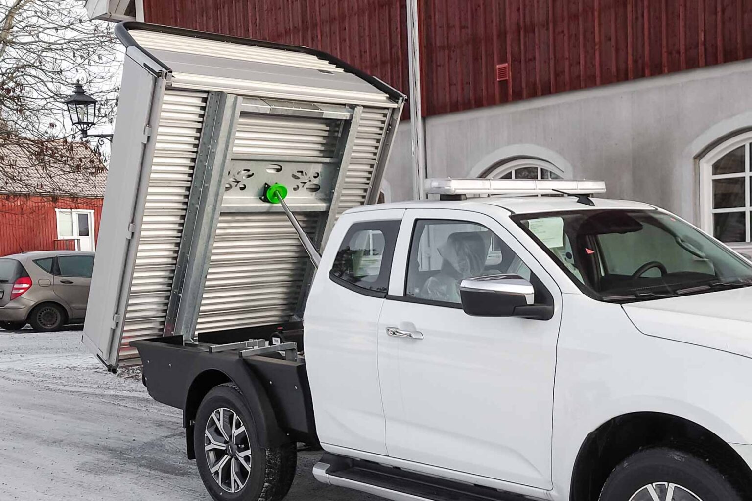 Tippflak Almeco pickup Isuzu D-Max. Extrautrustning: svart kjolpaket som döljer ramen, takbelysning ljusramp.